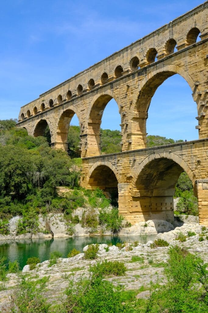 a stone bridge over a river surrounded by trees