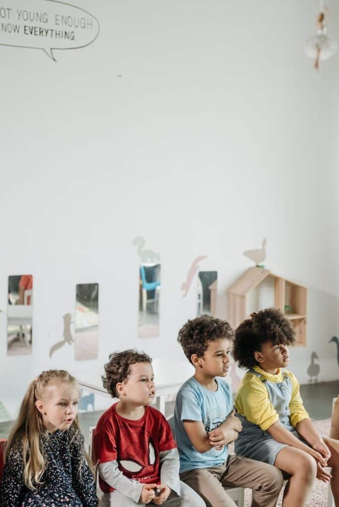Children sitting in a classroom, showcasing diversity and learning environment.